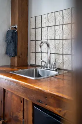 a kitchen with a sink in a wooden counter top at Owl's Nest Suites in Carrying Place
