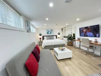 a living room with a couch and a bed at Modern Lux Family Rooms - KingBed - Near Sheppard W Station Toronto in Toronto