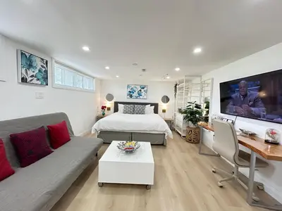 a living room with a bed and a couch at Modern Lux Family Rooms - KingBed - Near Sheppard W Station Toronto in Toronto
