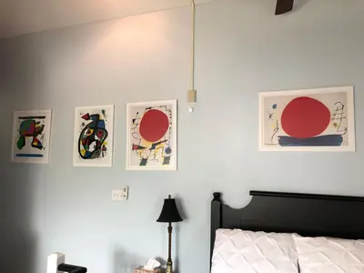 a bedroom with a bed with four pictures on the wall at Artistic Hillside Loft in Blue Mountains