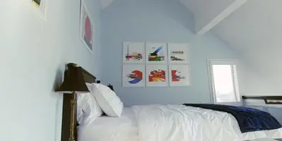 a bedroom with blue walls and a bed with white sheets at Artistic Hillside Loft in Blue Mountains