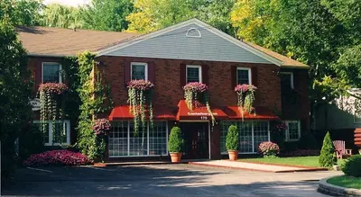 a red brick house with flowering plants on it at Canterbury Inn in Niagara on the Lake