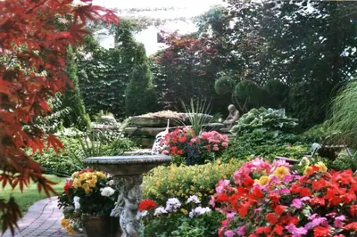 a garden with colorful flowers and a bird bath at Canterbury Inn in Niagara on the Lake