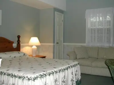 a bedroom with a bed and a couch at Canterbury Inn in Niagara on the Lake