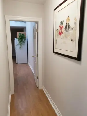 a hallway with a picture hanging on a wall and a door at Cozy Private Rm Heart of North York Free Parking Full Kitchen Close to Downtown in Toronto