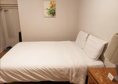 a bedroom with a bed with white sheets at Cozy Private Rm Heart of North York Free Parking Full Kitchen Close to Downtown in Toronto