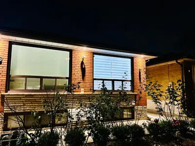 a brick house with two windows and a bench at Cozy basement room-Private Bath - Near Subway line 1 - Toronto in Toronto