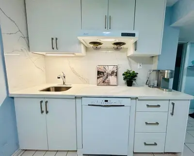 a kitchen with white cabinets and a sink at Cozy basement room-Private Bath - Near Subway line 1 - Toronto in Toronto
