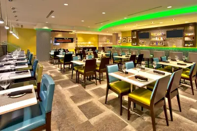 a restaurant with tables and chairs and a bar at Crowne Plaza Kitchener-Waterloo by IHG in Kitchener