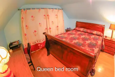 a bedroom with a wooden bed with a red bed frame at Comfort Home Toronto in Toronto