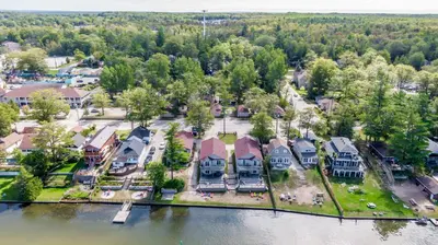 an aerial view of a large house on the water at Beach1 Riverfront Resort in Wasaga Beach