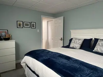 a bedroom with a large bed with a blue blanket at Hammer Haus II in Waterloo