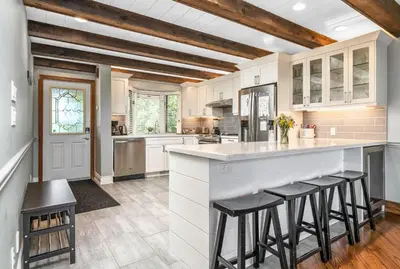 a kitchen with white cabinets and bar stools at Kawartha Lakes, Fenelon Falls in Fenelon Falls