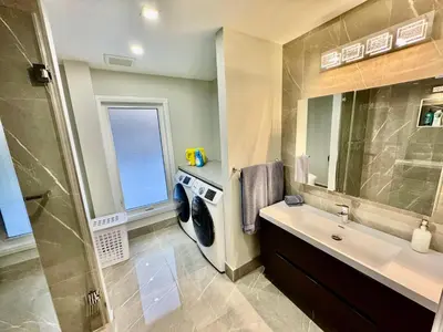 a bathroom with a washing machine and a sink at iResidence in Toronto - Fantastic Vacation Home with Breakfast in Toronto