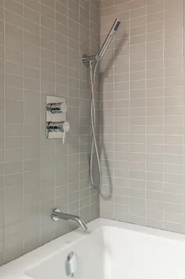 a shower in a tiled bathroom with a bath tub at Gorgeous Park House w Parking on Queen West in Toronto