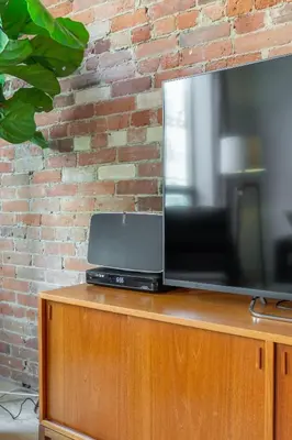 a television sitting on top of a wooden cabinet at Gorgeous Park House w Parking on Queen West in Toronto