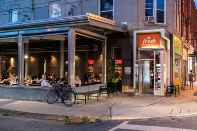 a restaurant with people sitting outside of it on a street at Gorgeous Park House w Parking on Queen West in Toronto