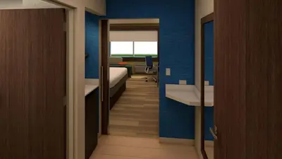 a room with a bedroom with a bed and a mirror at Holiday Inn Express & Suites - Aurora by IHG in Aurora