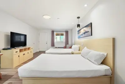 a bedroom with two beds and a flat screen tv at Saga Resort in Wasaga Beach