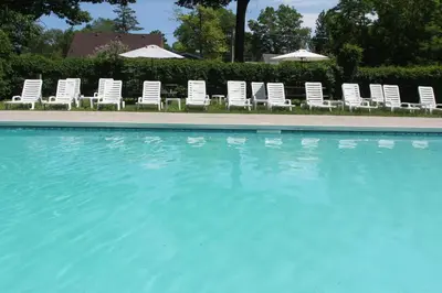 a group of chairs and umbrellas next to a swimming pool at Saga Resort in Wasaga Beach