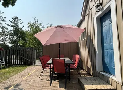a table and chairs with an umbrella on a patio at Saga Resort in Wasaga Beach