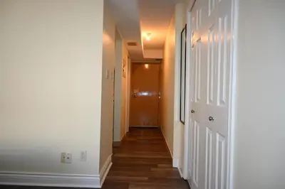 a hallway with white walls and wooden floors at Empire Suite in Niagara Falls