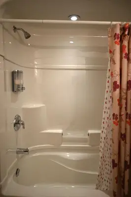 a bathroom with a tub and a shower curtain at Empire Suite in Niagara Falls