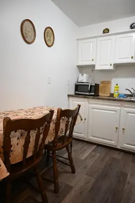 a kitchen with a table and chairs and a microwave at Empire Suite in Niagara Falls