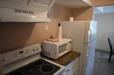 a kitchen with a microwave and a refrigerator at Elgin Suite in Niagara Falls