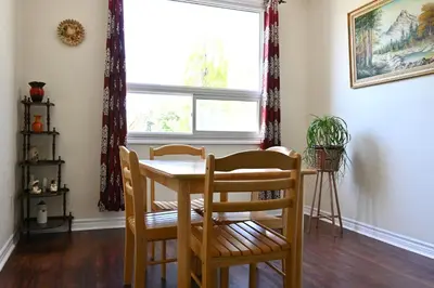 a dining room with a table and chairs and a window at Centennial Suite in Niagara Falls