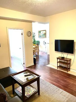 a living room with a tv and a coffee table at Centennial Suite in Niagara Falls
