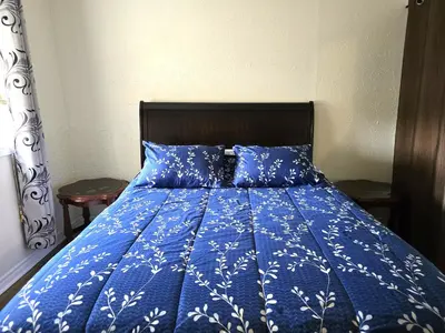 a bed with a blue comforter and blue pillows at Capitol Suite in Niagara Falls