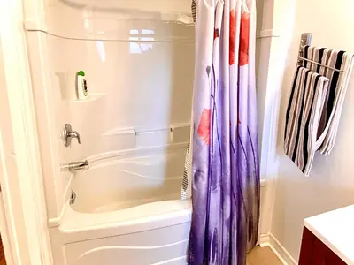 a bathroom with a tub and a shower curtain at Capitol Suite in Niagara Falls