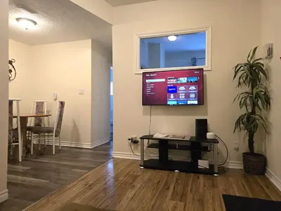 a living room with a flat screen tv on the wall at Capitol Suite in Niagara Falls