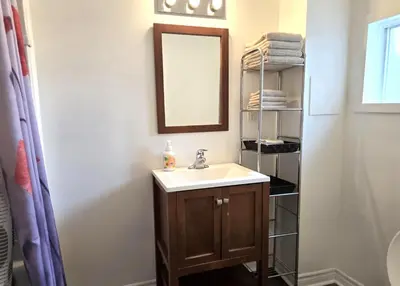 a bathroom with a sink and a mirror and towels at Capitol Suite in Niagara Falls