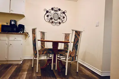 a table and chairs in a kitchen with a mirror on the wall at Capitol Suite in Niagara Falls