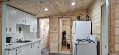 a kitchen with a white refrigerator and a sink at Trent River Cottages in Hastings
