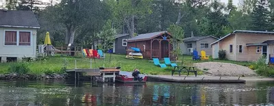 a group of houses and a boat on the water at Trent River Cottages in Hastings
