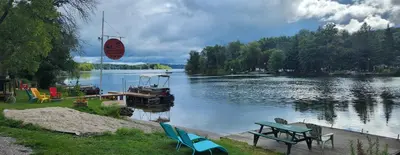 a picnic table and a boat on a lake at Trent River Cottages in Hastings