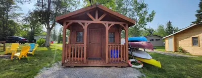 a small wooden gazebo sitting on the grass at Trent River Cottages in Hastings