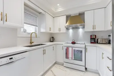 a white kitchen with white cabinets and a sink at Luxury Adventure, Rutherford Go station & Wonderland in Vaughan