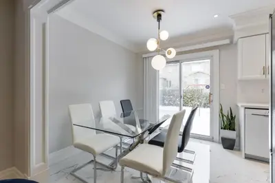 a dining room with a glass table and white chairs at Luxury Adventure, Rutherford Go station & Wonderland in Vaughan