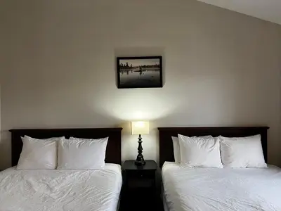 a bedroom with two beds and a picture on the wall at Inn at the Falls in Bracebridge