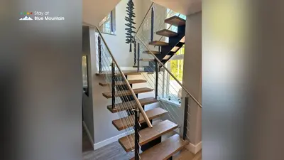 a staircase in a home with wooden treads at Orchard Run Chalet in Blue Mountains