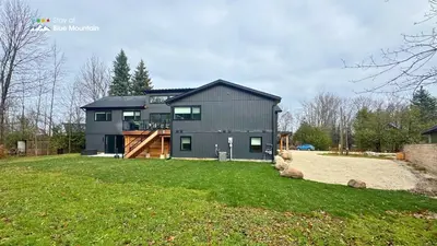 a large gray house with a large yard at Orchard Run Chalet in Blue Mountains