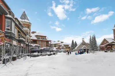 a snow covered street in a town with buildings at Ski In Out Chateau Ridge Chalet on Ski Run in Blue Mountains