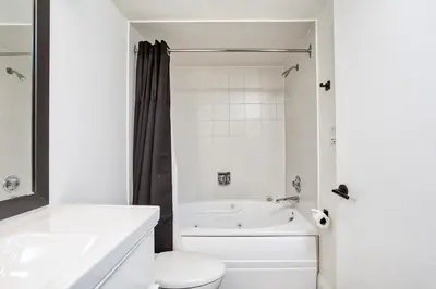 a white bathroom with a tub and a toilet at 2 BR Ski In Out at Cachet Crossing, Sleeps 8 in Blue Mountains