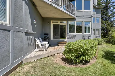 a house with a wooden porch with two chairs on it at 2 BR Ski In Out at Cachet Crossing, Sleeps 8 in Blue Mountains