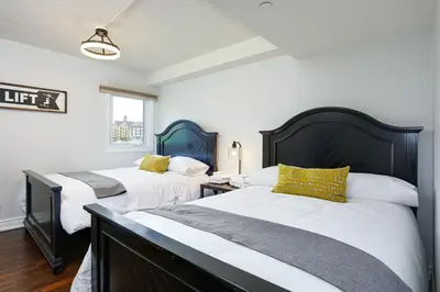 two beds in a bedroom with white and yellow pillows at Blue Mountain, 3 BR - 108 Mountain Walk Chalet in Blue Mountains