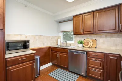 a kitchen with wooden cabinets and a sink and a microwave at Blue Mountain, 3 BR - 108 Mountain Walk Chalet in Blue Mountains